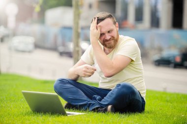 açık havada şehirde çalışan genç adam'ın bahçesinde, bir dizüstü bilgisayar ile