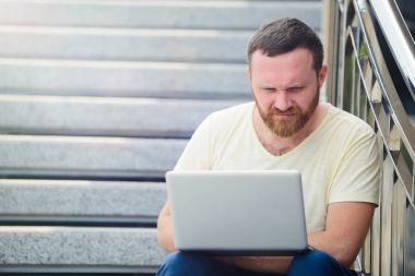 açık havada şehirde çalışan genç adam bankta, dizüstü bilgisayar ile