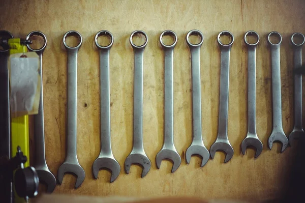 Spanners in the workshop hanging on a wooden background — Stock Photo, Image