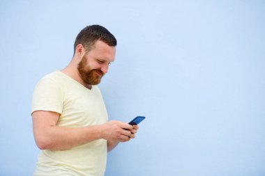 Kızıl Sakal ile neşeli adam telefona mavi bir arka plan üzerinde görünüyor.