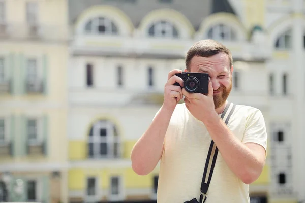 Człowiek z brodą turysty z kamerą w mieście, jasny, słoneczny dzień — Zdjęcie stockowe