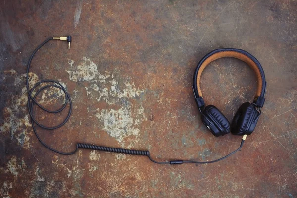 Brown classic headphones with a wire on a rusty background — Stock Photo, Image