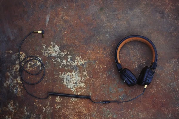 Brown classic headphones with a wire on a rusty background — Stock Photo, Image