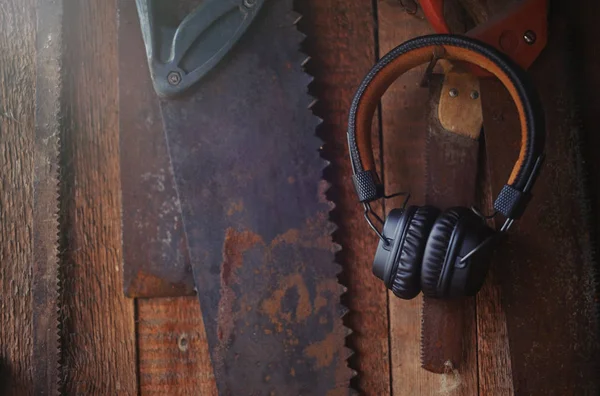 Беспроводные наушники коричневый на фоне столярных инструментов, ремесла и отдыха — стоковое фото