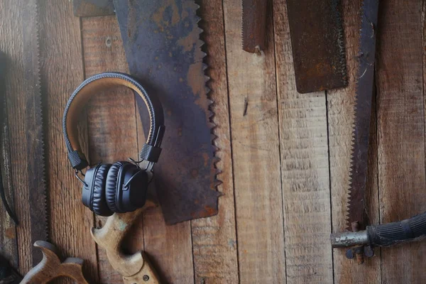 Auriculares inalámbricos marrones en el fondo de las herramientas de carpintería, artesanía y ocio — Foto de Stock