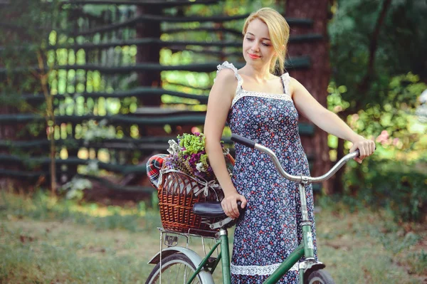 Una mujer sana. Belleza Chica modelo de verano con colores brillantes bosque de bicicletas y cesta. estilo de ocio. Una hermosa dama con el pelo rubio. Bonita cara. Maquillaje cosmético moda — Foto de Stock