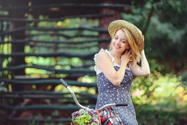 Eine gesunde Frau. Schönheit Sommer Modell Mädchen mit hellen Farben Fahrrad Wald und Korb. Freizeit im Stil. hob eine schöne Dame ihre Hand. Nettes Gesicht. Platz für Banner und Werbung — Stockfoto