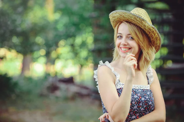 A healthy woman. Beauty Summer model girl with bright flowers happy forest. style leisure. A beautiful white lady in a straw hat. A nice face with a smile and a mystery. place for banner and advertise — Stock Photo, Image