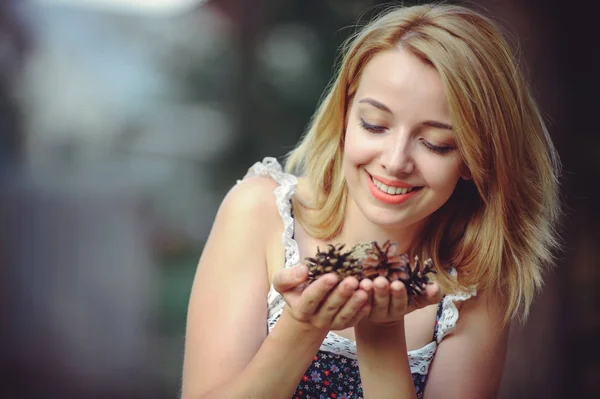 Una mujer sana. Belleza Chica modelo de verano con flores brillantes conos lsnovye. estilo de ocio. Una hermosa dama blanca sonríe. Una cara dulce es un misterio. lugar para la bandera y la publicidad — Foto de Stock