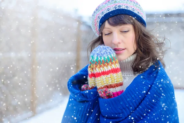 Retrato de inverno de uma jovem. Beauty Joyous Model Girl tocando sua pele de rosto e rindo, se divertindo no parque de inverno. Mulher bonita ao ar livre. Desfrutando de natureza, inverno e vendas de neve — Fotografia de Stock