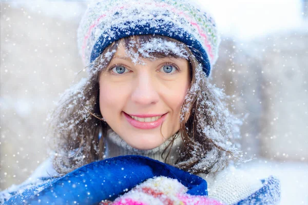 Retrato de inverno de uma jovem. Beauty Joyous Model Girl tocando sua pele de rosto e rindo, se divertindo no parque de inverno. Mulher bonita ao ar livre. Desfrutando de natureza, inverno e vendas de neve — Fotografia de Stock