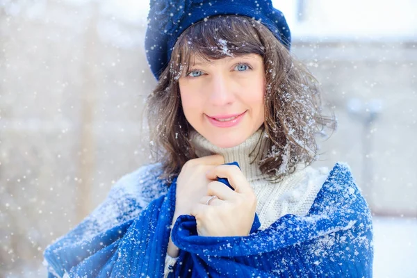 Retrato de invierno de una mujer joven. Beauty Joyous Model Girl tocándose la piel de la cara y riéndose, divirtiéndose en el parque de invierno. Hermosa joven al aire libre. Disfrutando de las ventas de naturaleza, invierno y nieve — Foto de Stock