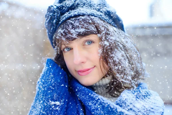 Retrato de inverno de uma jovem. Beauty Joyous Model Girl tocando sua pele de rosto e rindo, se divertindo no parque de inverno. Mulher bonita ao ar livre. Desfrutando de natureza, inverno e vendas de neve — Fotografia de Stock