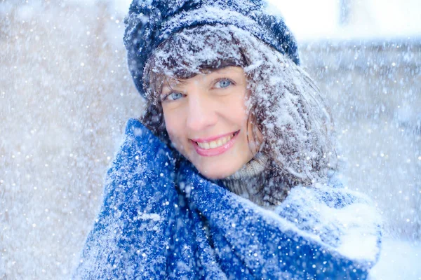 Retrato de invierno de una mujer joven. Beauty Joyous Model Girl tocándose la piel de la cara y riéndose, divirtiéndose en el parque de invierno. Hermosa joven riendo al aire libre. Disfrutando de la naturaleza, en invierno y s —  Fotos de Stock