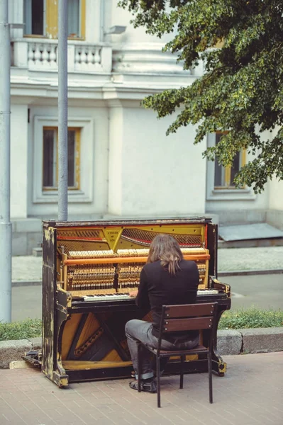 Уличный музыкант играет на старом шабби-фортепиано — стоковое фото