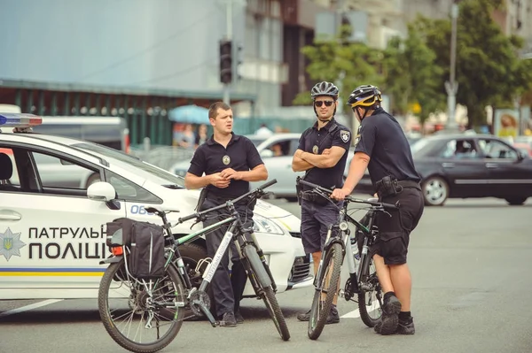 Carro de polícia e polícia em uma bicicleta — Fotografia de Stock
