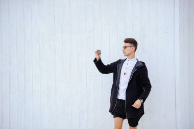 şık adam beyaz bir duvar. photogr ellerini yukarı doğru kaldırdı