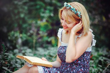 Kırsal kesimde piknik güzel ve genç birbayan. Mutlu rahat gün açık havada. Açık. Eller, Park'ta rahatlatıcı kitap ile gülümseyen kadın. rekreasyon