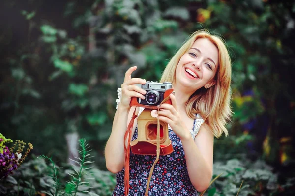 Mulher bonita fazendo um piquenique no campo. Feliz dia aconchegante ao ar livre. Abre. Mulher sorridente com câmera nas mãos, relaxando no parque. recreação — Fotografia de Stock