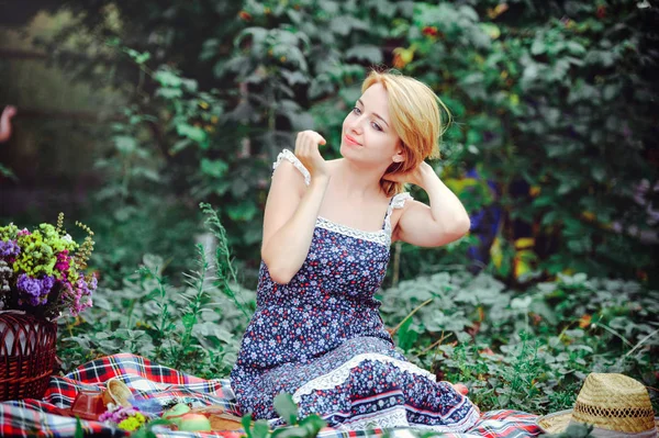 Mooie jonge vrouw met een picknick in het platteland. Gelukkig, gezellige dag in de buitenlucht. Open. Lachende vrouw aanraken van haren, ontspannen in het park. rust en gezondheid — Stockfoto