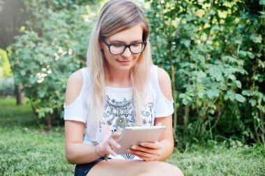 Tablet. Bir tablet üzerinde çalışan güzel bir kız. Modern teknolojiler. Bir tablet niteliğine kadınla