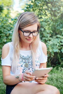 Tablet. Bir tablet üzerinde çalışan güzel bir kız. Modern teknolojiler. Bir tablet niteliğine kadınla