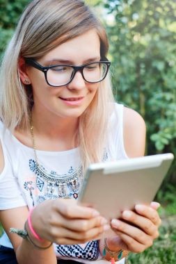Tablet. Bir tablet üzerinde çalışan güzel bir kız. Modern teknolojiler. Bir tablet niteliğine kadınla