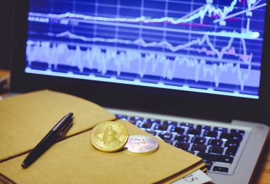 Bitcoin bir iş adamı bir bilgisayar arka plan ve artan bir grafik karşı not defterinde altın sikke olduğunu. Sanal Kripto para kavramı