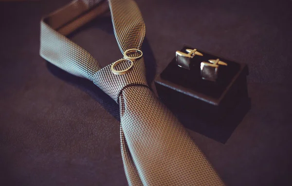 Cravatta nuziale, fedi nuziali in oro e gemelli, colore scuro accogliente — Foto Stock