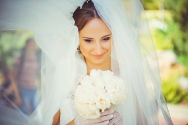 ihale mutlu gelin peçe, mutlu kadınla ellerini, buket düğün elbise içinde beyaz peçe yüz, yumuşak ve sıcak kapsar.