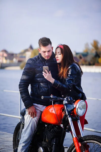 Стильная и модная влюбленная пара на мотоцикле, флиртующая крупным планом на фоне поздней осени в парке — стоковое фото
