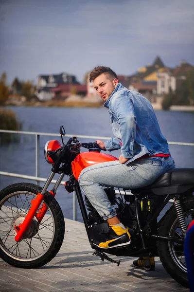 büyük bir motosiklet, atış, geç sonbaharda sıcak genç bir sportif moda adam portresi