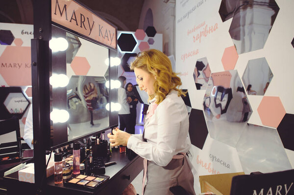 stand of Mary Kay make a make-up for a young woman at the Ukrainian Fashion Week
