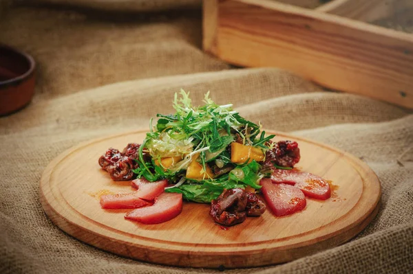 Exquisita ensalada con mango y fondo de madera de carne, tendido de mesa, acogedor restaurante que sirve primer plano — Foto de Stock