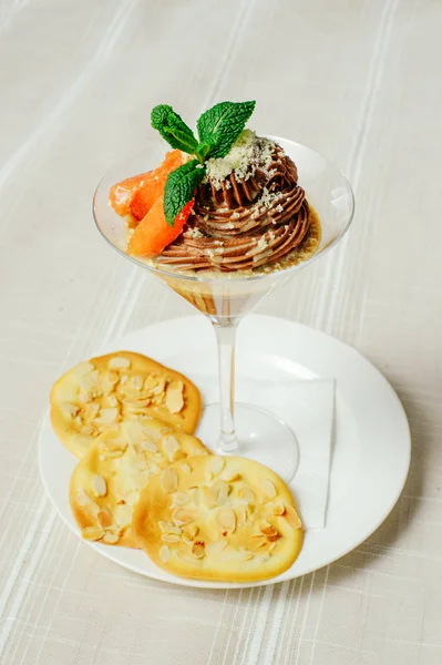 Schokoladendessert mit Graufrucht-Keksen und Minze in raffinierter Servierform, gemütlicher heller Tischdekoration, Restaurantservice — Stockfoto