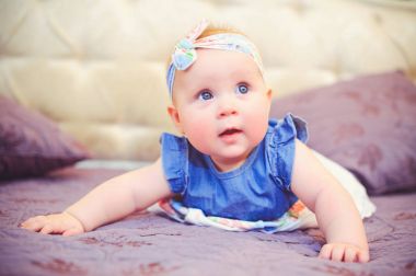 yatakta yatarken bir buçuk yaşındaki çocuk portresi, mavi elbise ve bir bandaj başında, 6 ay yaşlı annesinin kollarında ile giyinmiş mutludur. Çocukların, çocuk mal kavram eğitimi