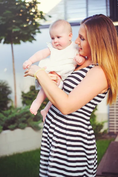 Femme avec un sein de bébé, une mère tenant une fille dans ses bras sont heureux dans une maison de campagne, le concept de parentalité, enfance — Photo