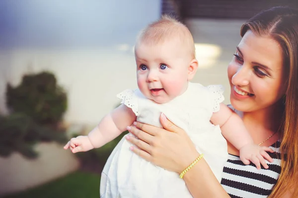 Portrait d'une femme avec un sein de bébé, maman tenant une fille dans ses bras sont heureux dans une maison de campagne, le concept de parentalité, enfance — Photo