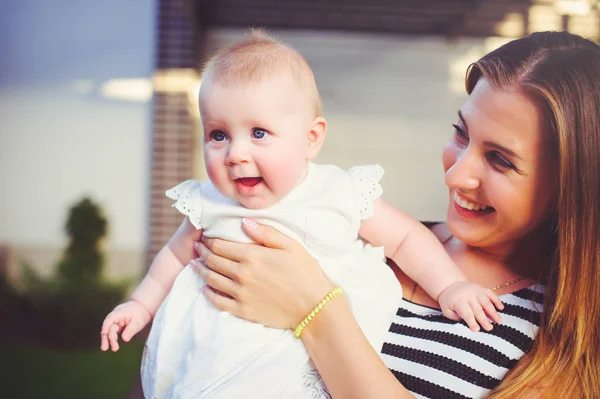 Portrait d'une femme avec un sein de bébé, maman tenant une fille dans ses bras sont heureux dans une maison de campagne, le concept de parentalité, enfance — Photo