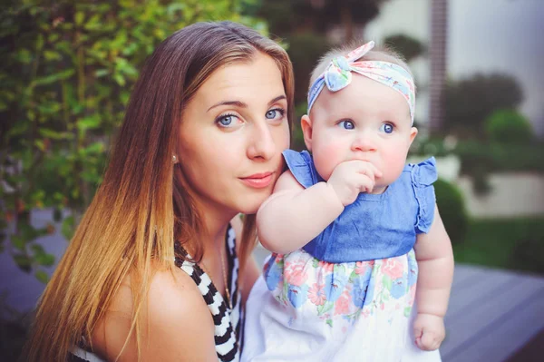 Portrait d'une femme heureuse avec un bébé suceur assis, mère tenant sa fille dans ses bras se réjouissant dans une maison de campagne, concept d'élever des enfants, enfance — Photo