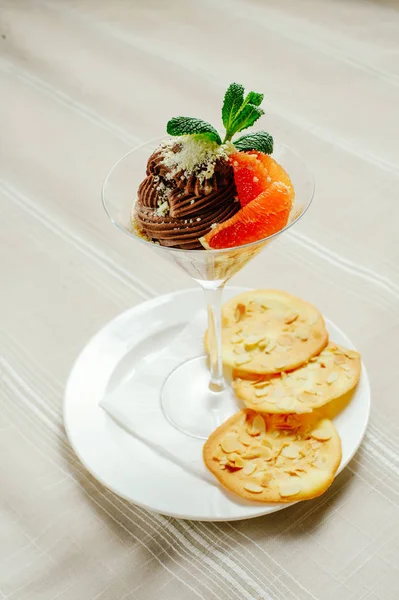 Шоколадный десерт с серыми фруктами печенья и мяты в изысканной подаче, уютный светлый стол настройки, ресторан подают — стоковое фото