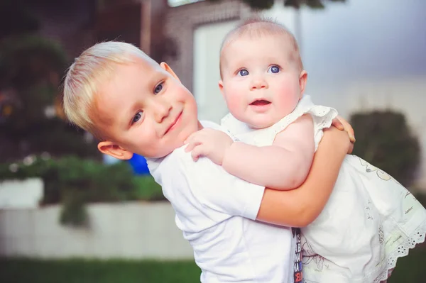 Heureux petit frère jouer câlins sa soeur bébé, garçon et fille embrasse, concept amour et parental — Photo