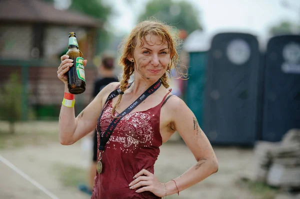 A mulher a vencedora depois supera uma barreira de lama de água durante a corrida de poder Legião Run, teve lugar em Kiev — Fotografia de Stock