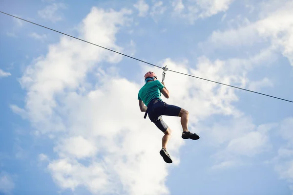 Człowiek schodzi na liny, sport w extreme park, mężczyznę idącego wzdłuż linii zip — Zdjęcie stockowe