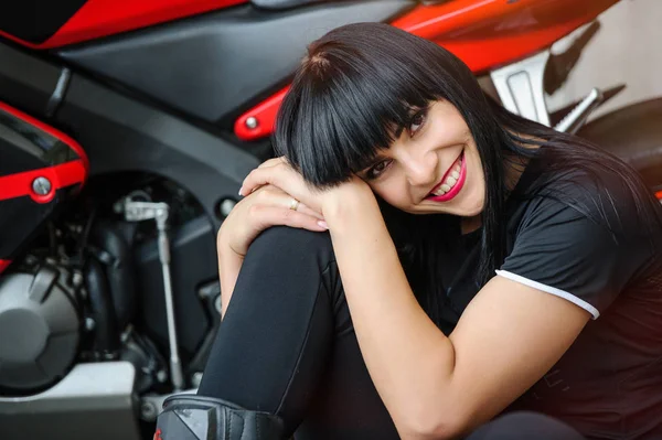 都市に座ったポーズのスポーツ バイクで黒い服を着たバイカーの女の子 — ストック写真