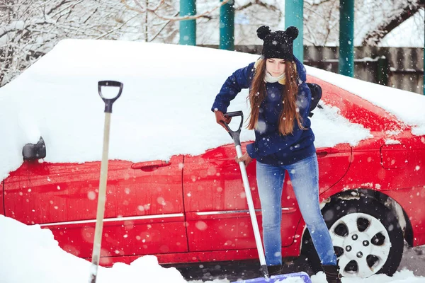 Winterporträt einer jungen Frau beim Schneeräumen. Schönheit freudige Model Mädchen lachen und Spaß mit einer Schaufel. schöne junge Frau im Freien — Stockfoto