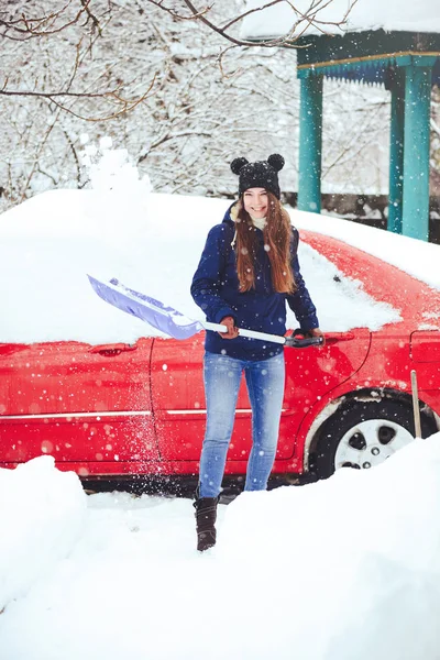 Winterporträt einer jungen Frau beim Schneeräumen. Schönheit freudige Model Mädchen lachen und Spaß mit einer Schaufel. schöne junge Frau im Freien — Stockfoto