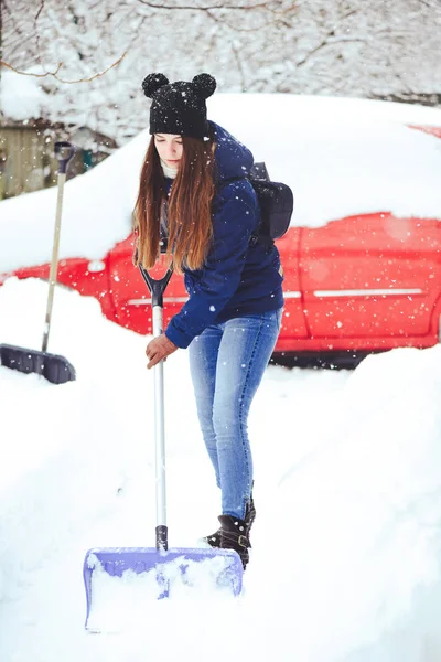 Winterporträt einer jungen Frau beim Schneeräumen. Schönheit freudige Model Mädchen lachen und Spaß mit einer Schaufel. schöne junge Frau im Freien — Stockfoto