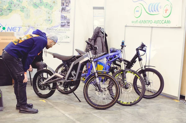 Hombre busca bicicleta eléctrica moderna tecnología y protección del medio ambiente en las calles de la venta de la ciudad — Foto de Stock