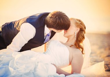  gün batımında sahilde çift yalan düğün, bir yelek bir adam onun sevgili, sıcak ve samimi görüntü, dinlenme ve romantik ilişki kisses
